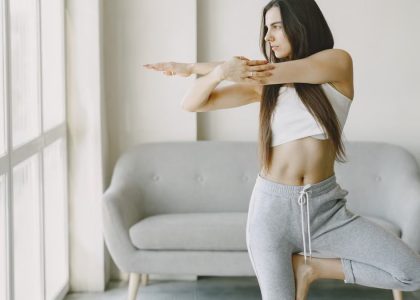 A woman performs a yoga pose at home, focusing on balance and tranquility.